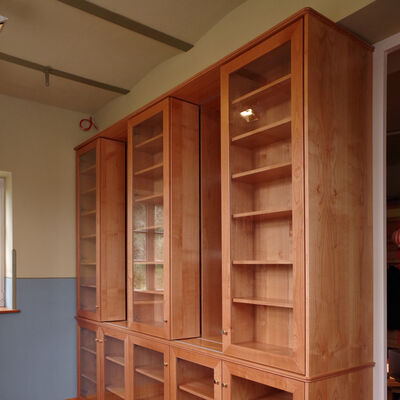 Bücherschrank in Kirschbaum. Vordere Regale sind verschiebbar. 